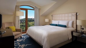 A hotel room with a large bed, a desk, a chair, and a view of the outdoors. - Tsaghkadzor Marriott Hotel (Tsaghkadzor)