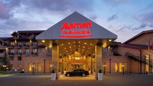 A Marriott hotel entrance with a car parked in front, multiple balconies, and a well-lit facade. - Tsaghkadzor Marriott Hotel (Tsaghkadzor)
