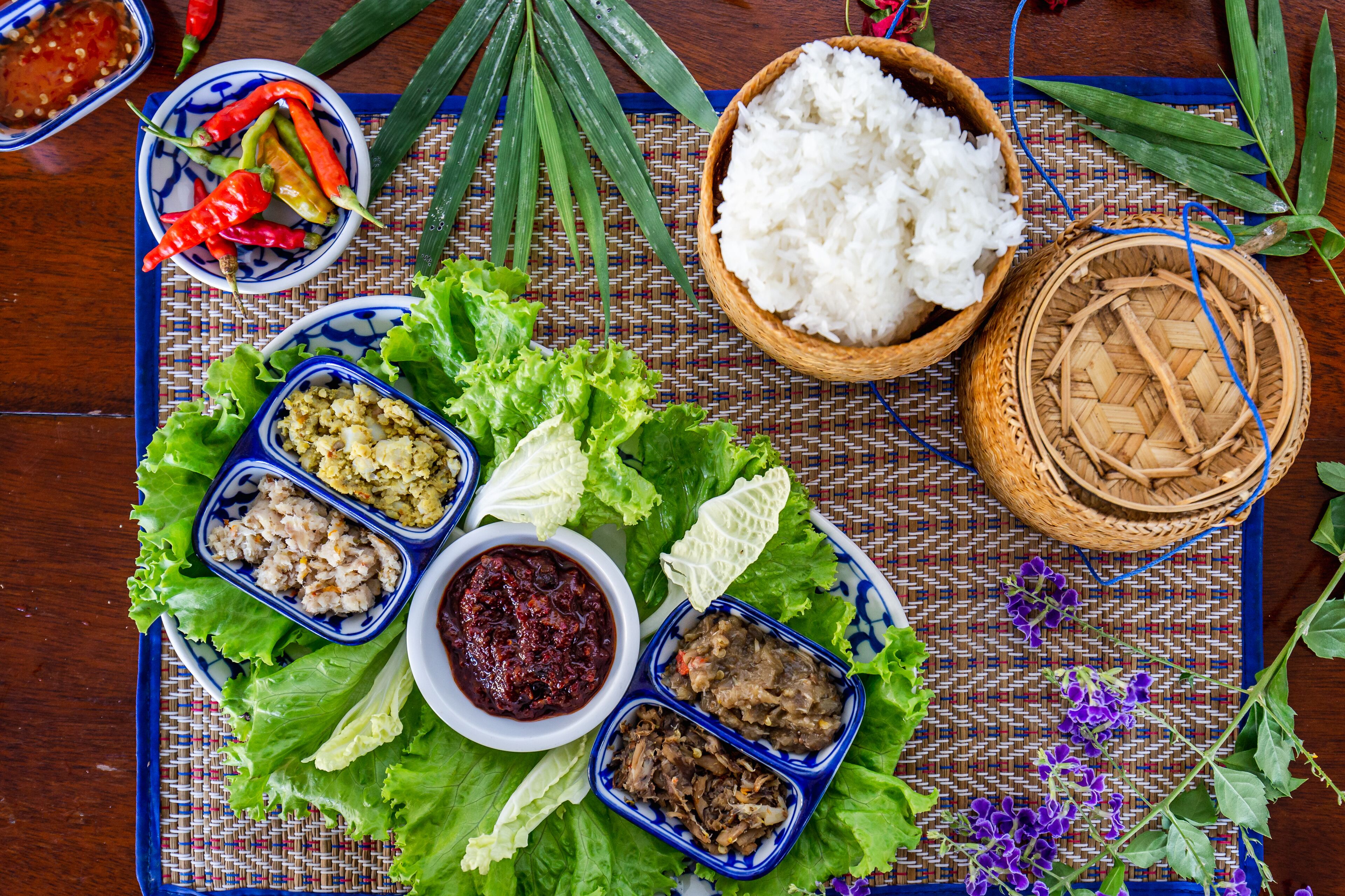 A table with various dishes including rice, vegetables, and sauces.