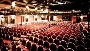 A theater with rows of red seats and a stage area. - Herston Place Motel (Herston)