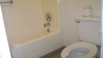 A bathroom with a bathtub, toilet, and a towel rack.