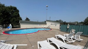 A swimming pool with lounge chairs and a covered area. - Motel Beechmont (Cincinnati)