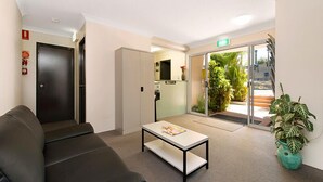 A modern reception area with a black leather sofa, a white coffee table, and a reception desk. - Chermside Court Motel (Chermside)