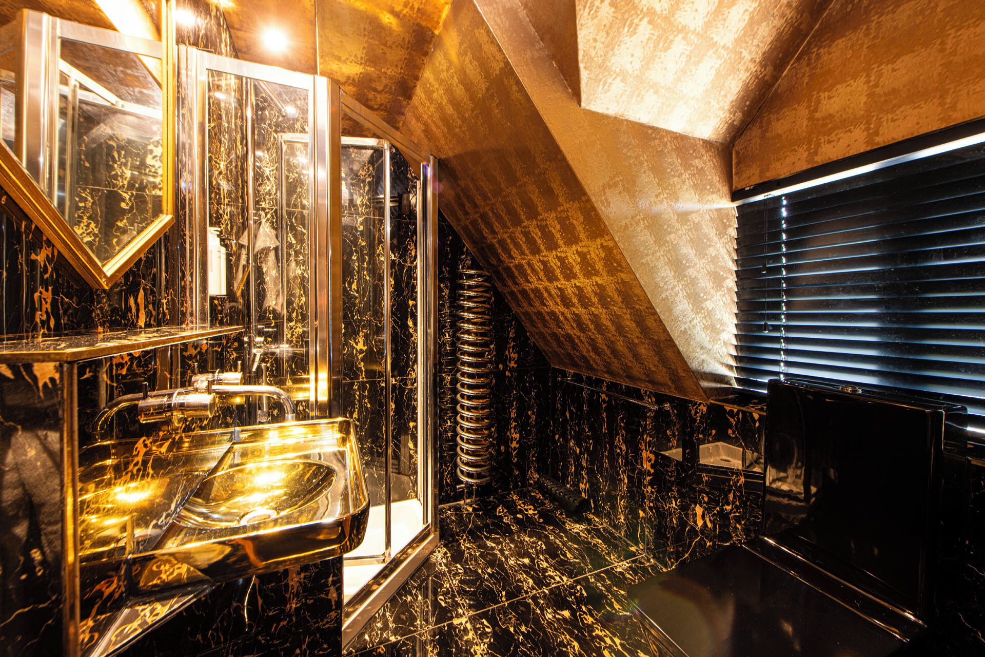 A luxurious bathroom with marble flooring, a large mirror, and a bathtub.