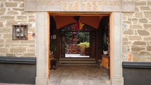 A stone building entrance with a sign reading "POSADA ACASONA DE CORTES".