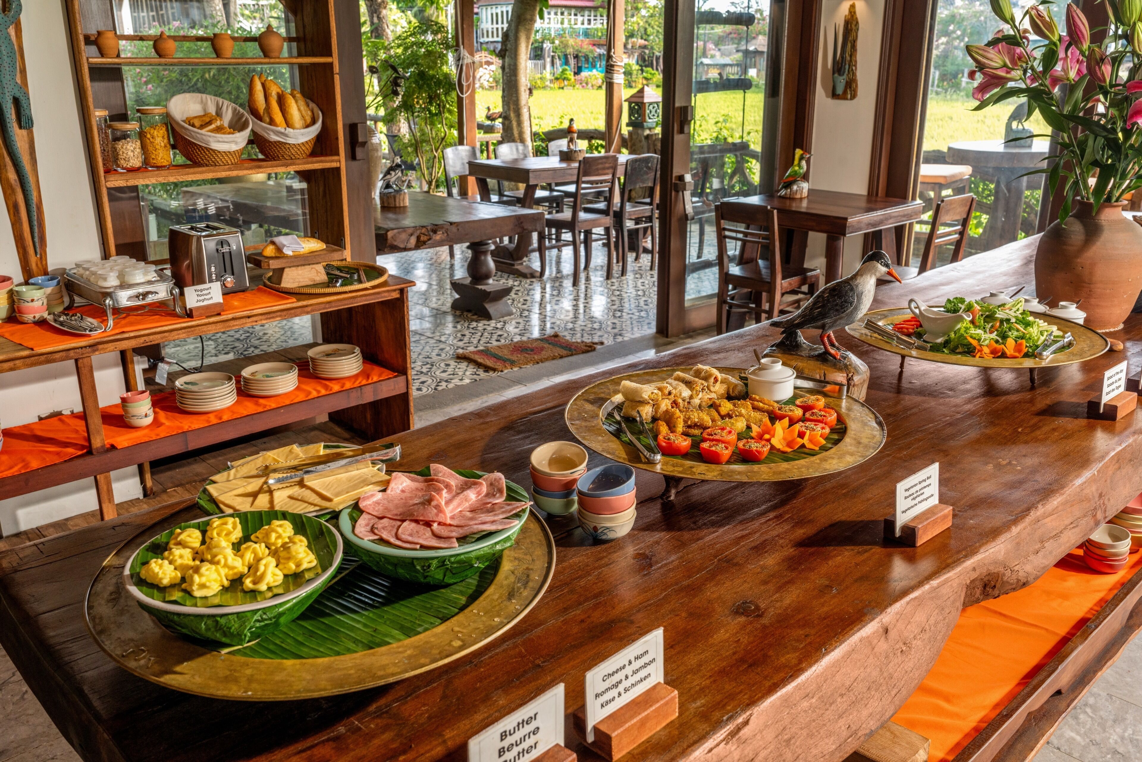 Buffet com diversos alimentos e um pássaro no balcão.