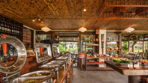 Montaje tipo buffet con varias estaciones de servicio, techo de madera y vistas al exterior.