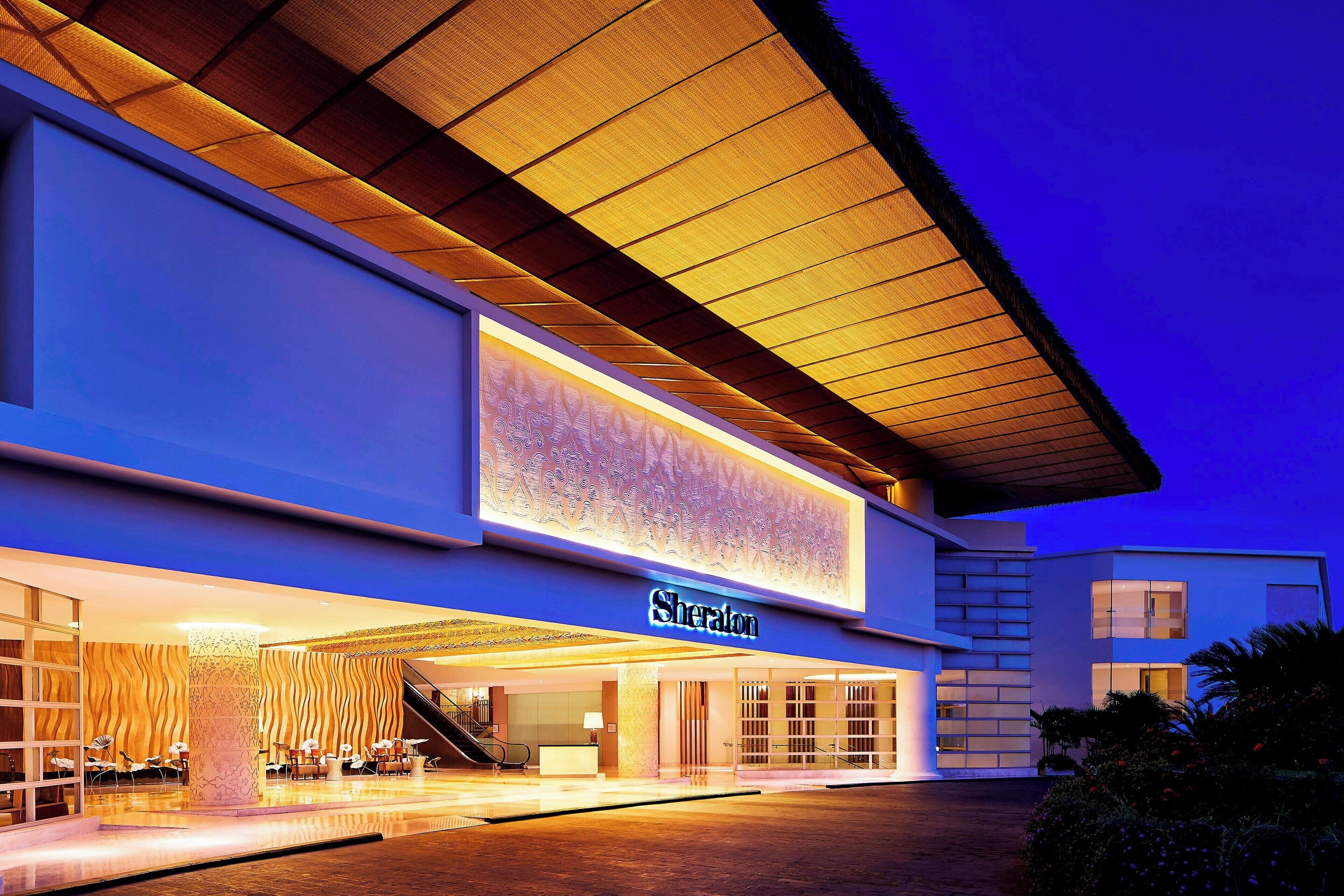 A Sheraton hotel with a modern facade, a prominent entrance, and a covered outdoor area.