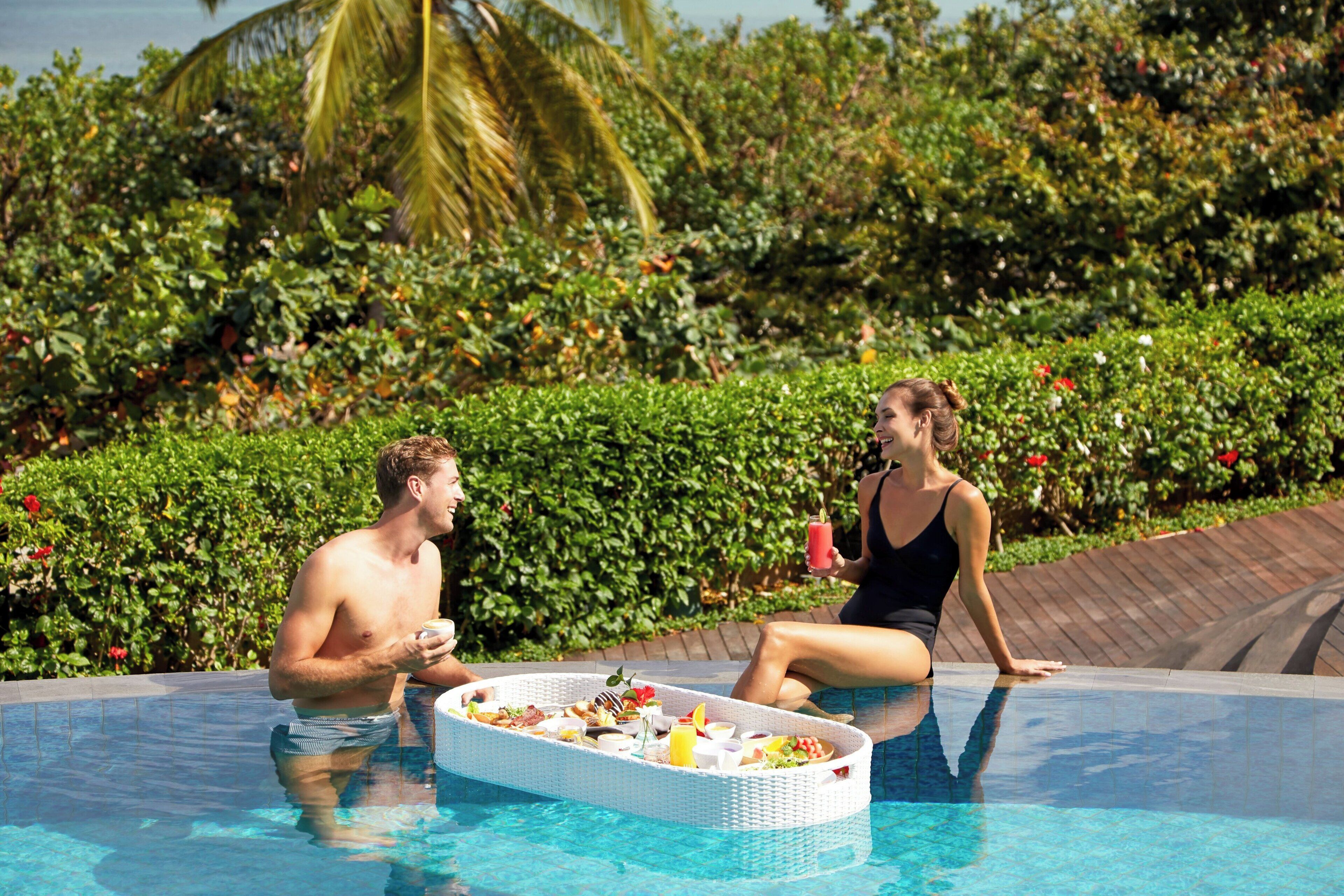 A poolside setting with a dining table and drinks.