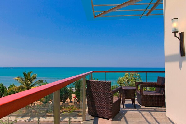 A balcony with wicker furniture and a view of the ocean. - Sheraton Bali Kuta Resort (Kuta)