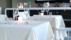 A restaurant with tables set for dining, each with wine glasses and cutlery. - Idea Hotel Plus Savona (Savona)