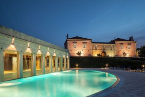 A swimming pool with a building in the background. - Casas Novas Countryside Hotel Spa & Events (Chaves)