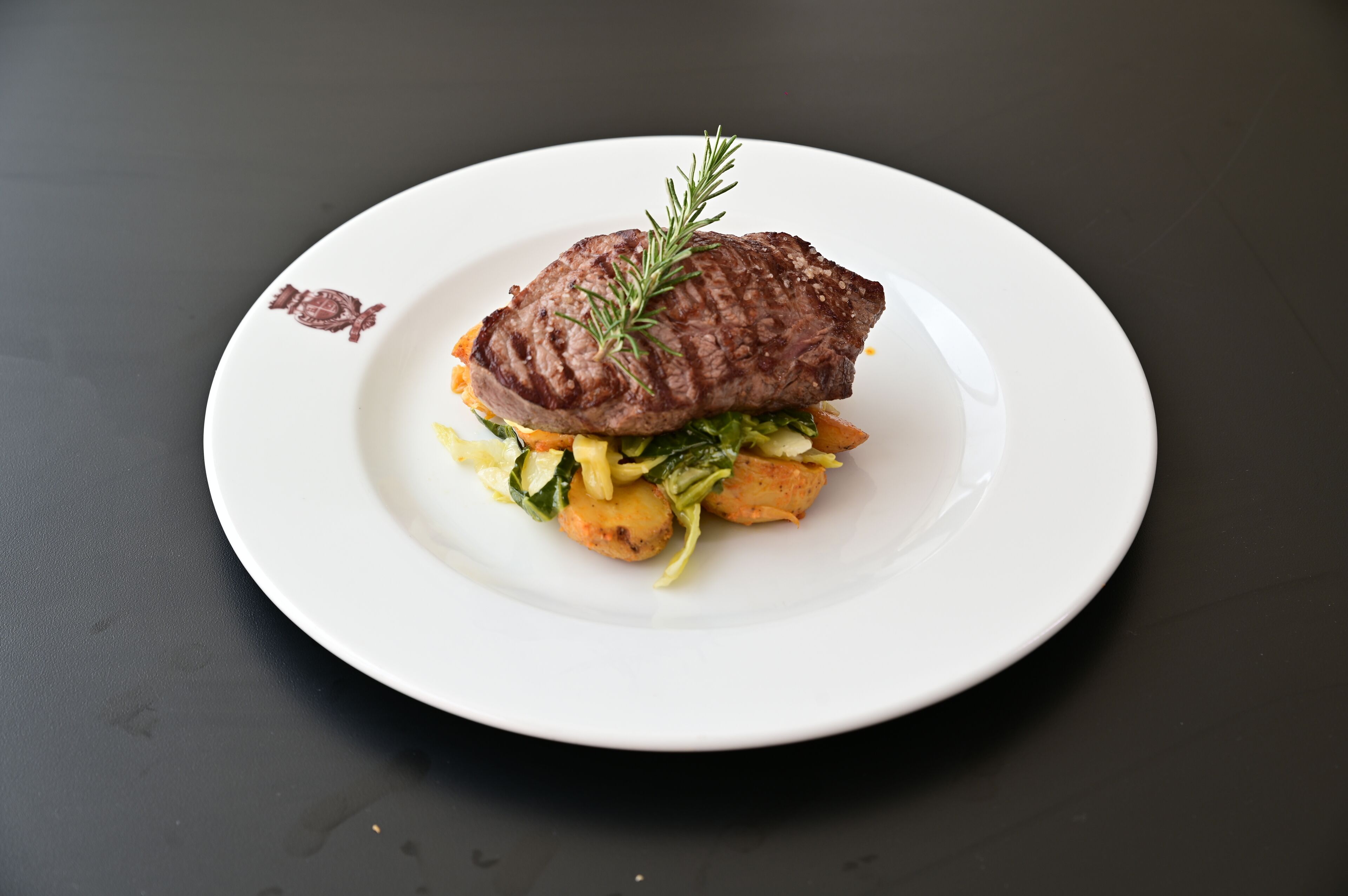 Um prato com sanduíche de bife sobre um prato branco.