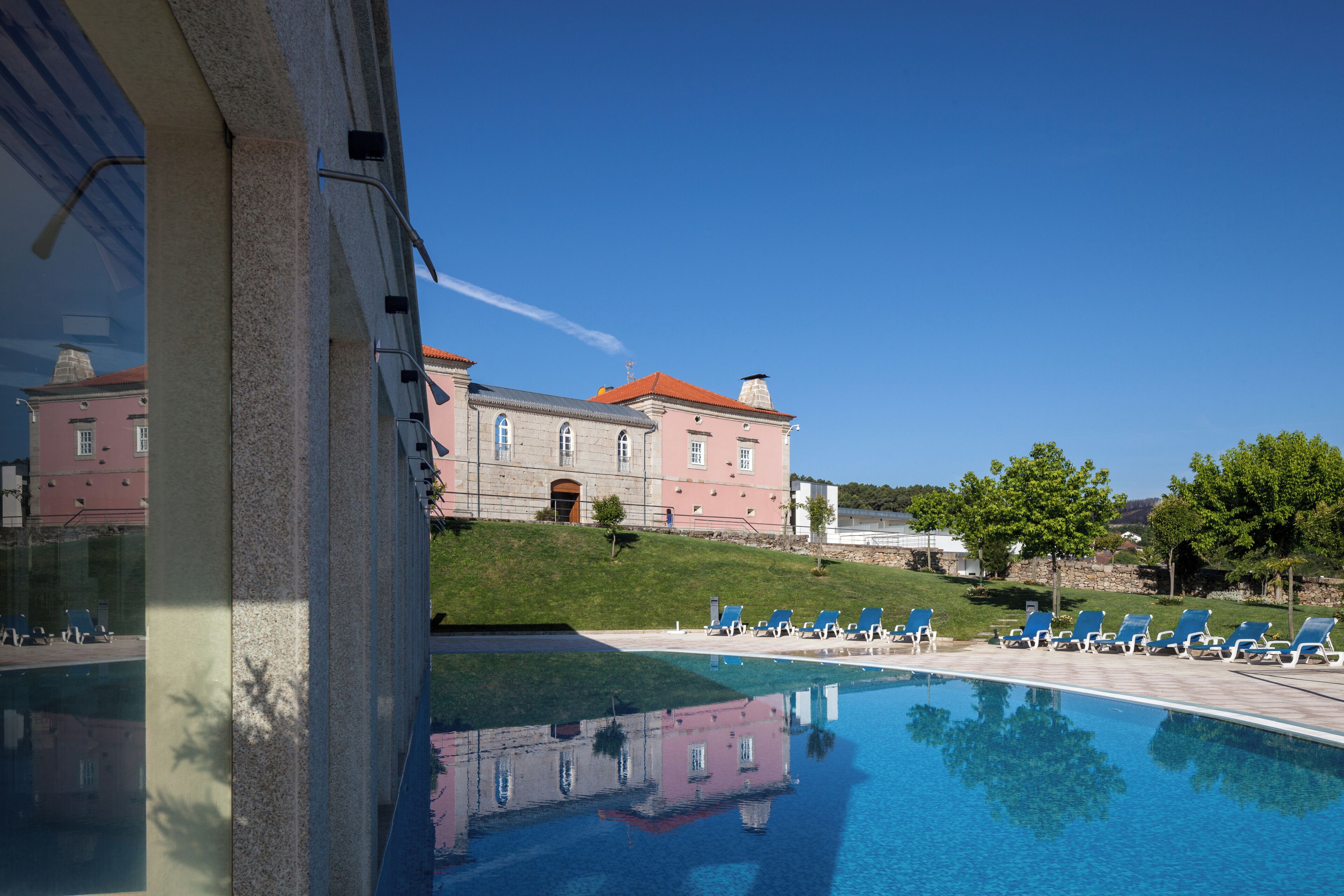 Een binnenzwembad, een buitenzwembad en ligstoelen