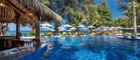 Een buitenzwembad, ligstoelen bij het zwembad