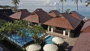 Un resort con varias edificaciones, piscina y palmeras.