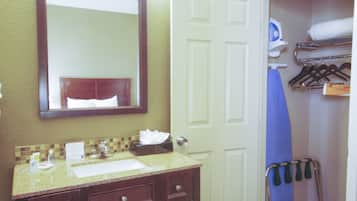 A bathroom with a sink, mirror, and towel rack.