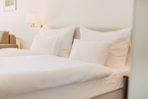 Ropa de cama hipoalergénica y caja de seguridad en la habitación 