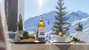 Una mesa de restaurante dispuesta con una botella de vino, un bol y un árbol de Navidad.