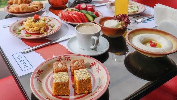 A table with breakfast items and a view of ancient ruins.