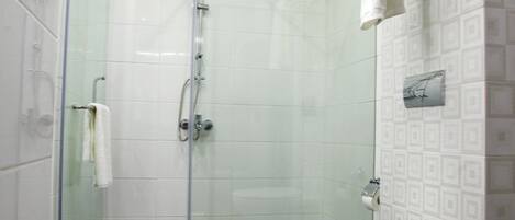 A modern bathroom with a glass-enclosed shower, a toilet, and patterned tiles.