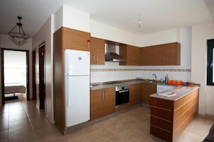 Una cocina moderna con armarios de madera, horno empotrado y encimera de granito.