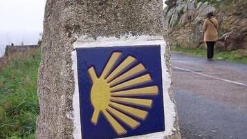 A stone marker with a sun symbol and a distance marker of 0.00 K.M.