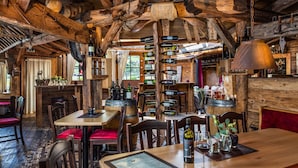 A rustic wooden interior with a wooden dining table, chairs, and a menu. - AlpenParks Hotel Montana Matrei (Matrei in Osttirol)