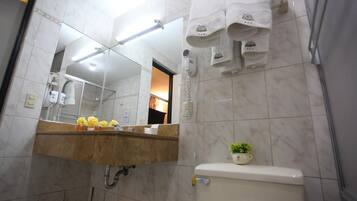 Une salle de bain avec un lavabo en marbre, un miroir, des toilettes et un porte-serviettes.