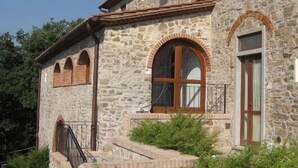 Un bâtiment en pierre doté de fenêtres en arc de cercle et d’une porte en bois.
