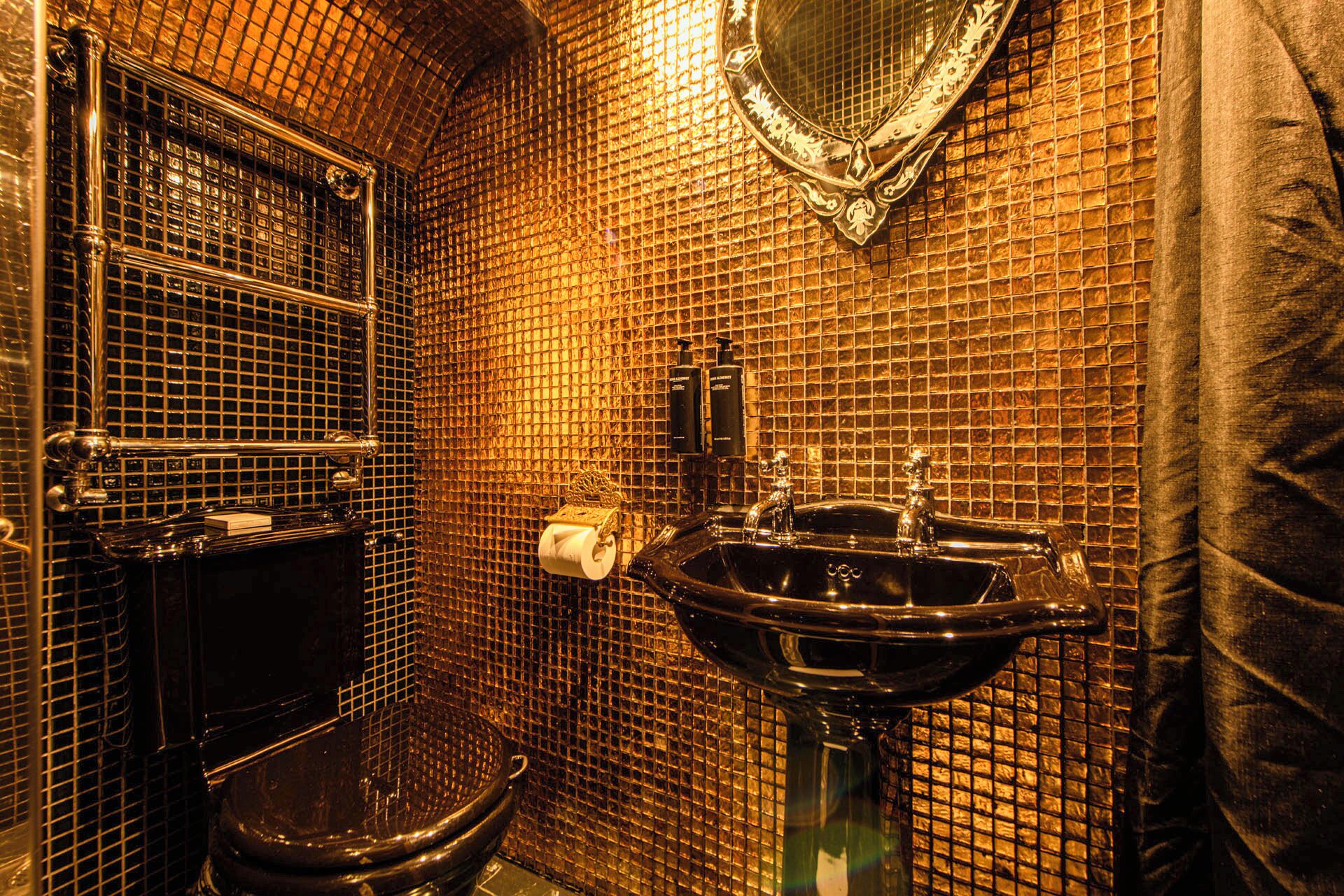 Une salle de bain avec une baignoire noire, un lavabo et des toilettes.