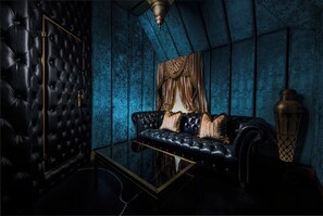 A room with a black leather sofa, a glass coffee table, and a decorative lamp. - Crazy Bear Hotel-Beaconsfield (Beaconsfield)