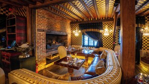 A cozy, checkered-patterned room with a fireplace, leather seating, and a wooden ceiling.