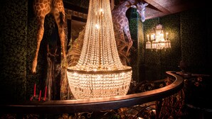 A chandelier with multiple lights, giraffes, and a wall-mounted lamp.