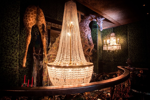 A chandelier with multiple lights, giraffes, and a wall-mounted lamp.