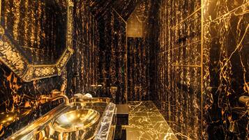A bathroom with a marble floor, a sink, and a mirror.