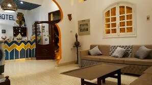 A hotel lobby with a reception desk, a sofa, and a coffee table. - Cleopatra Hotel Luxor (Luxor)