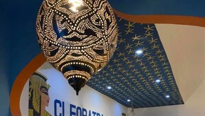 The interior of the Cleopatra Hotel with a prominent Egyptian-themed wall, a chandelier, and decorative columns. - Cleopatra Hotel Luxor (Luxor)