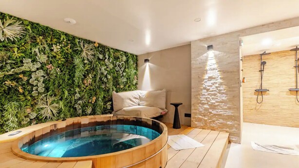 A modern bathroom with a wooden hot tub, a stone shower area, and a lush green wall. - Atypik Hôtel - Urban Style (Clichy)