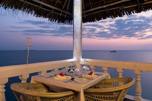 A table set for two with a view of the sea at sunset. - Chuini Zanzibar Beach Lodge by NEWMARK (Bububu)