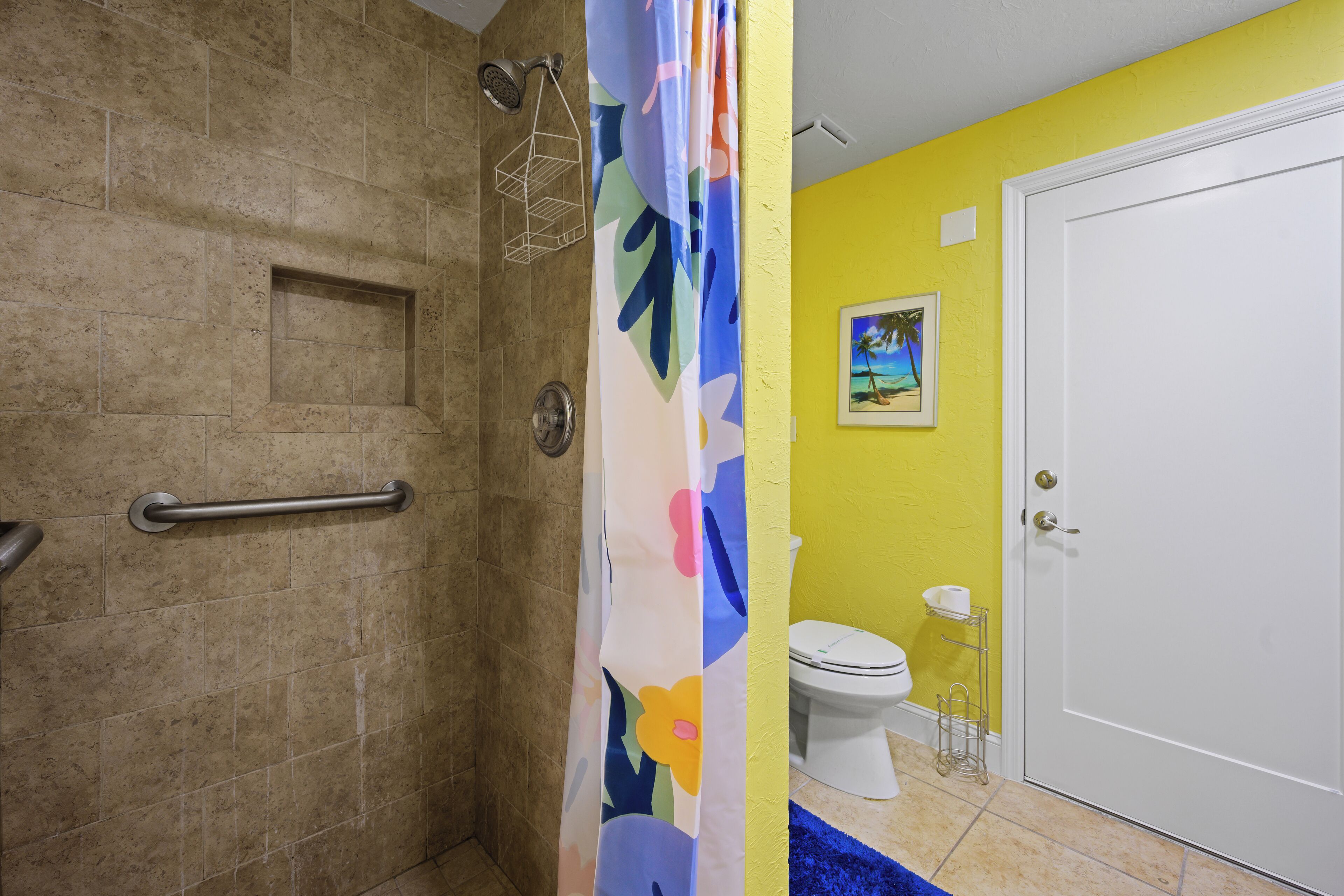 A bathroom with a shower, toilet, and a door.
