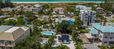 A coastal resort with multiple buildings, a swimming pool, and a beach view.