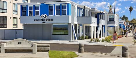 A modern hotel with a prominent "Pacific View" sign, featuring a large window and a balcony.