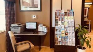 A reception desk with a computer, printer, and informational brochures.