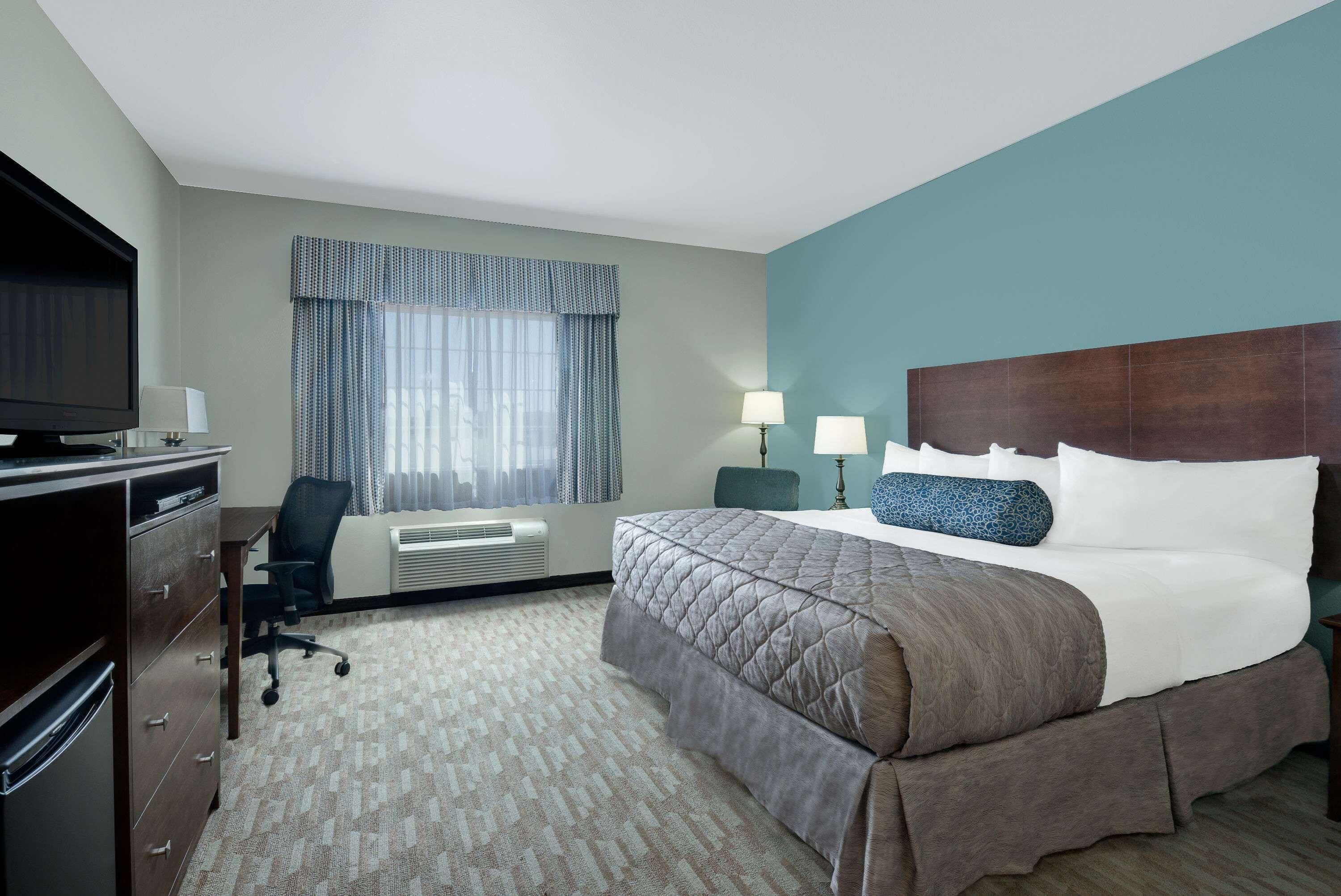 Une chambre d’hôtel équipée d’un lit, d’un bureau, d’une chaise, d’une télévision et d’un appareil de climatisation.