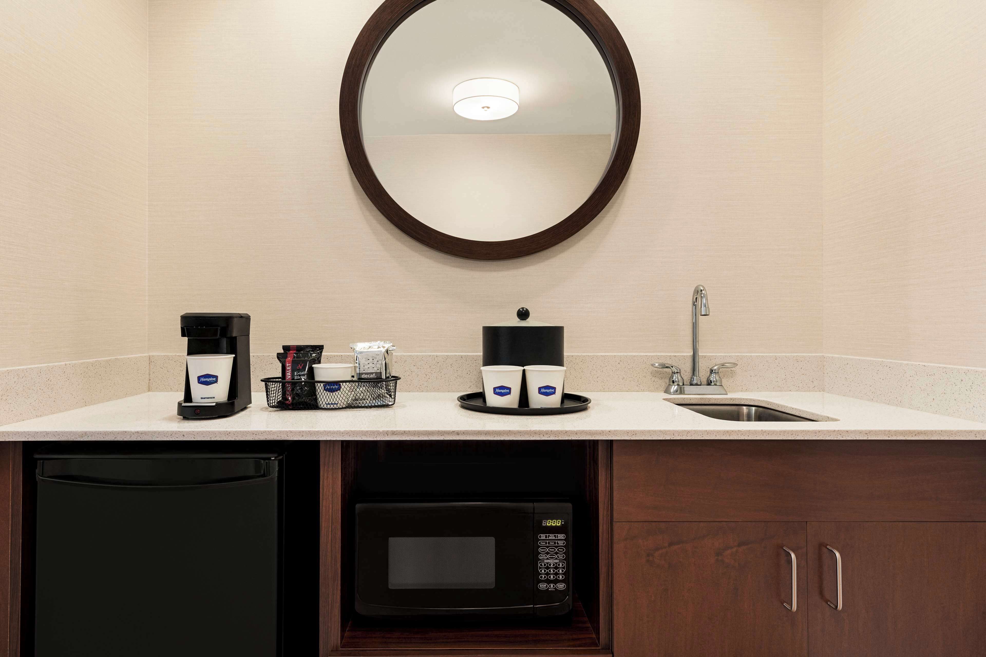 Un bagno d'hotel con lavandino, macchina del caffè e forno a microonde.