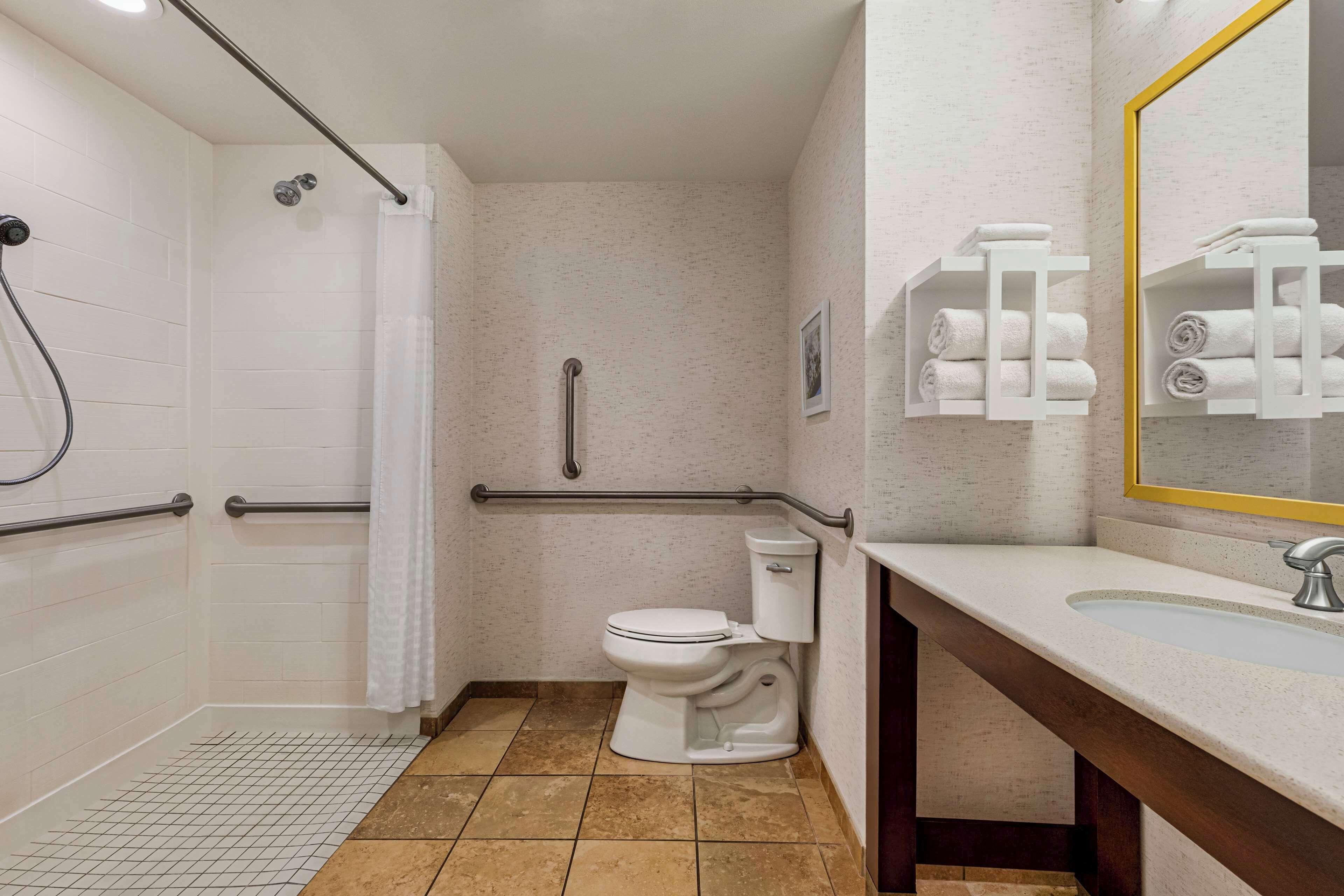 A bathroom with a shower, toilet, and sink.