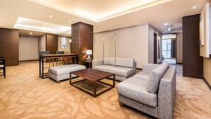 A modern hotel lobby with a seating area, a wooden coffee table, and a sofa. - Holiday Inn Xi'an Big Goose Pagoda by IHG (Xi'an)