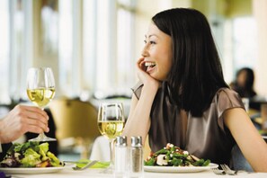 A dining table with a plate of salad, a glass of white wine, and salt and pepper shakers. - Holiday Inn Xi'an Big Goose Pagoda by IHG (Xi'an)