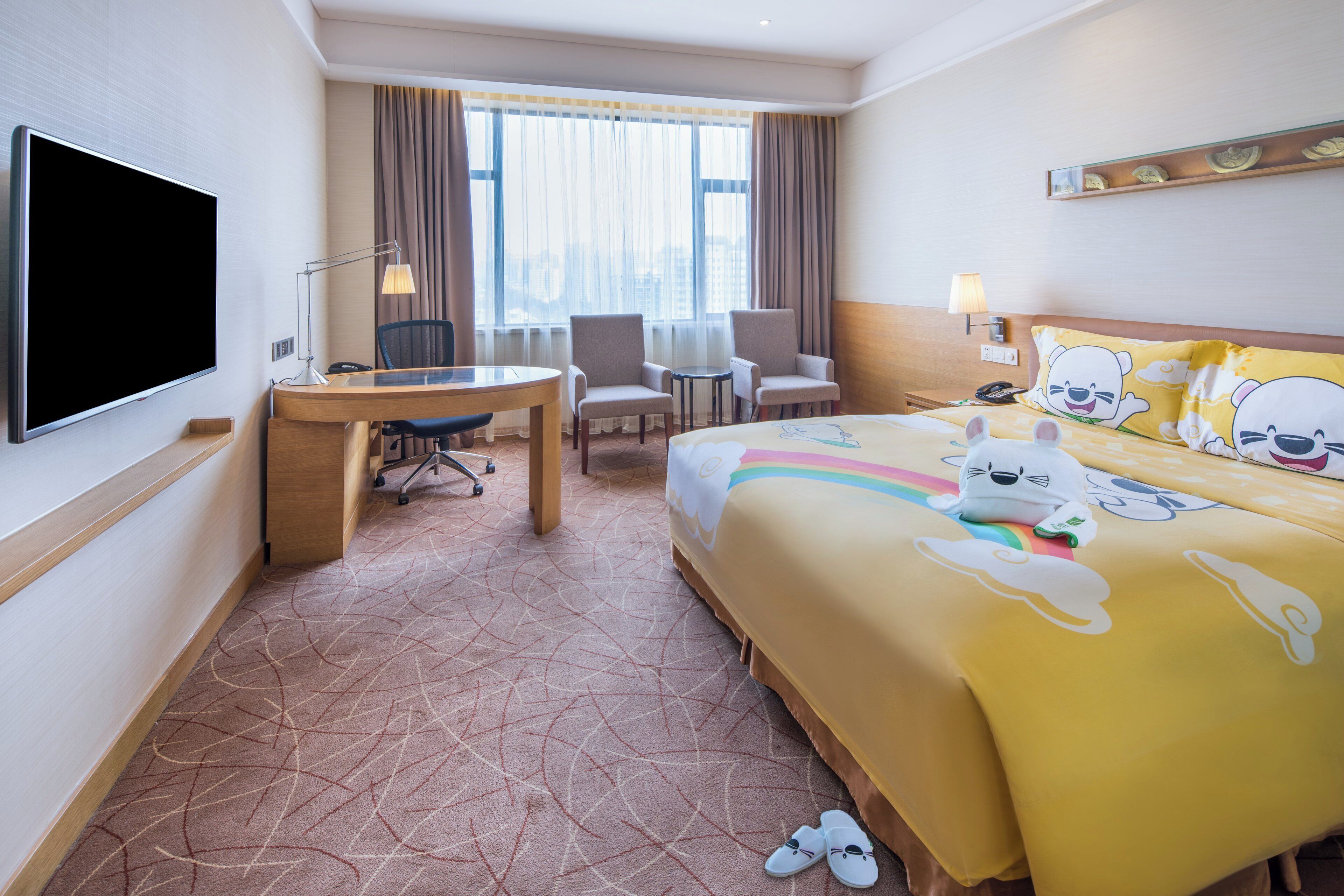 Une chambre d’hôtel avec un lit, un bureau, une chaise, une télévision et une fenêtre avec des rideaux.